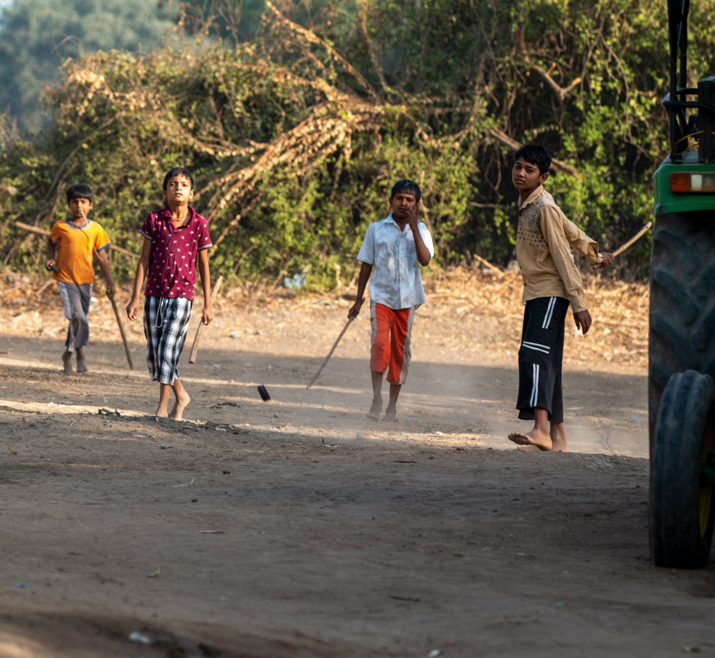 Children carrying makeshift cricket bats